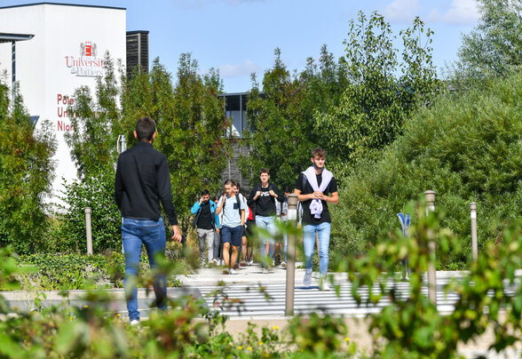 Étudiants marchant sur l'allée du Pôle Universitaire Niortais, bâtiment de l'Université de Poitiers visible en arrière-plan - Agrandir l'image, fenêtre modale