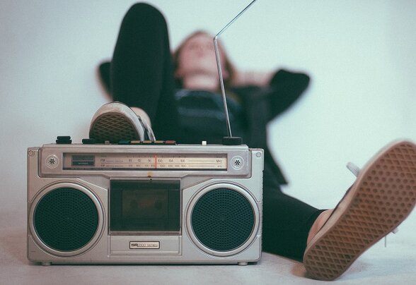 Personne allongée sur le sol, se relaxant à côté d'un radio-cassette vintage - Agrandir l'image, fenêtre modale