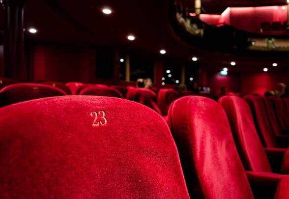 Sièges en velours rouge numérotés dans une salle de spectacle - Agrandir l'image, fenêtre modale