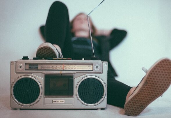 Personne allongée par terre écoutant de la musique sur un boombox vintage - Agrandir l'image, fenêtre modale
